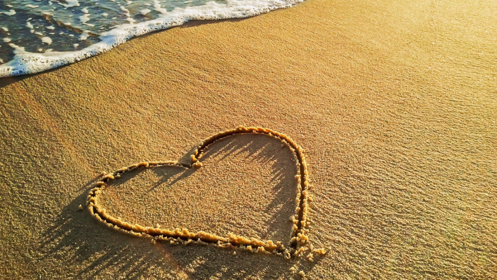 picture of a heart drawn in sand at the beach